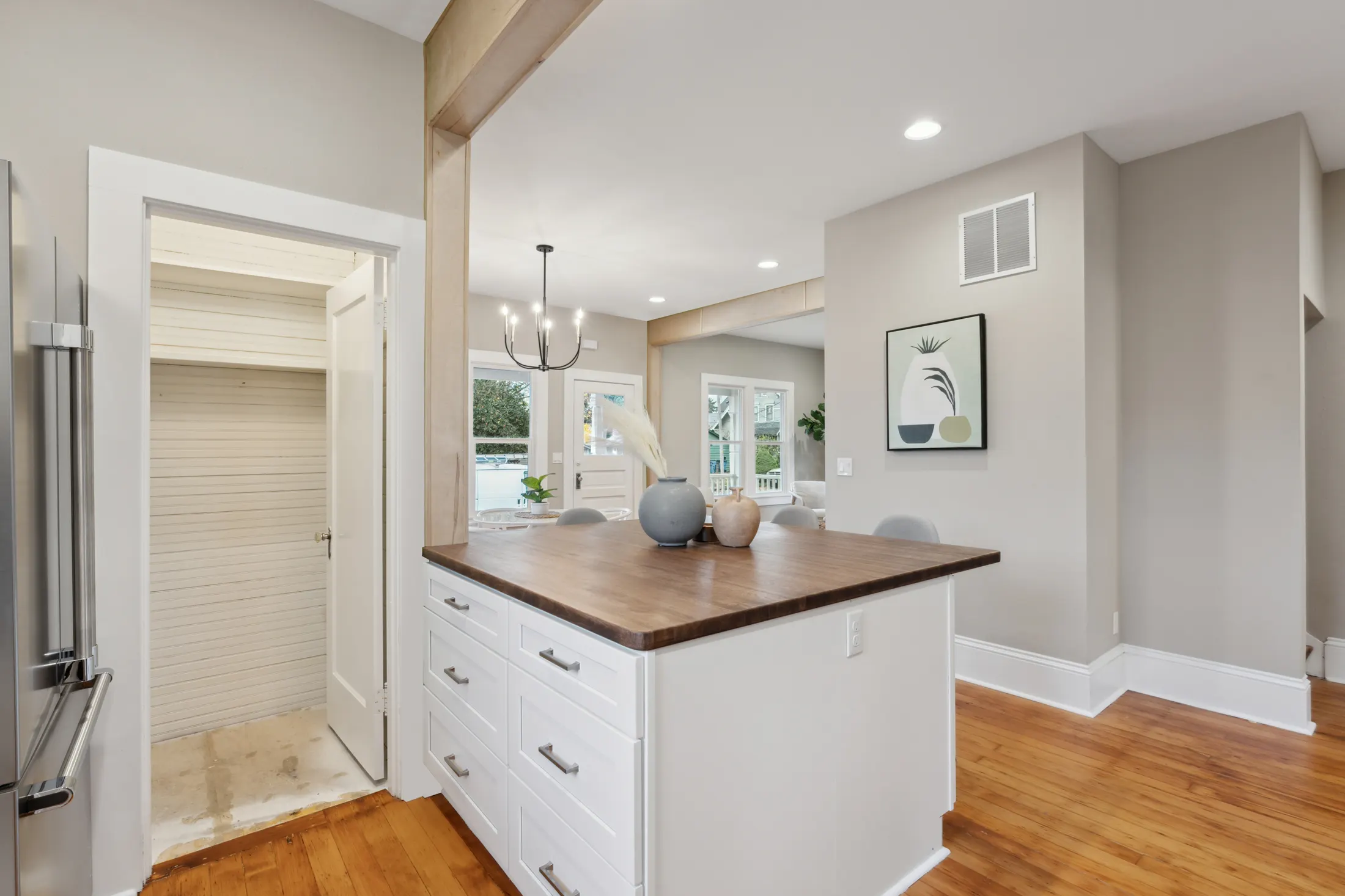 Kitchen island with butcher-block top open to the dining area by CRM Services
