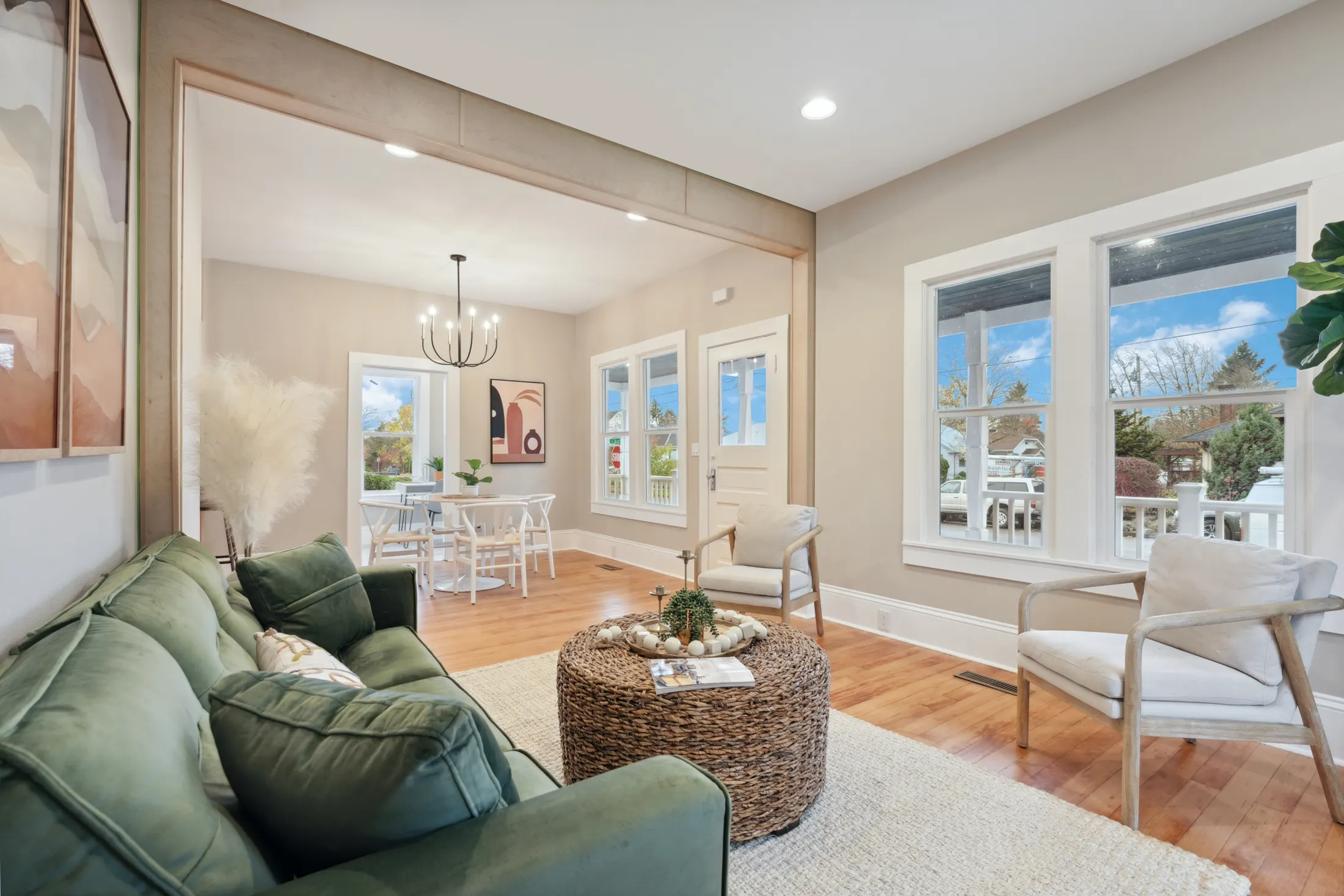 Staged living room opening to the dining area with hardwood floors by CRM Services