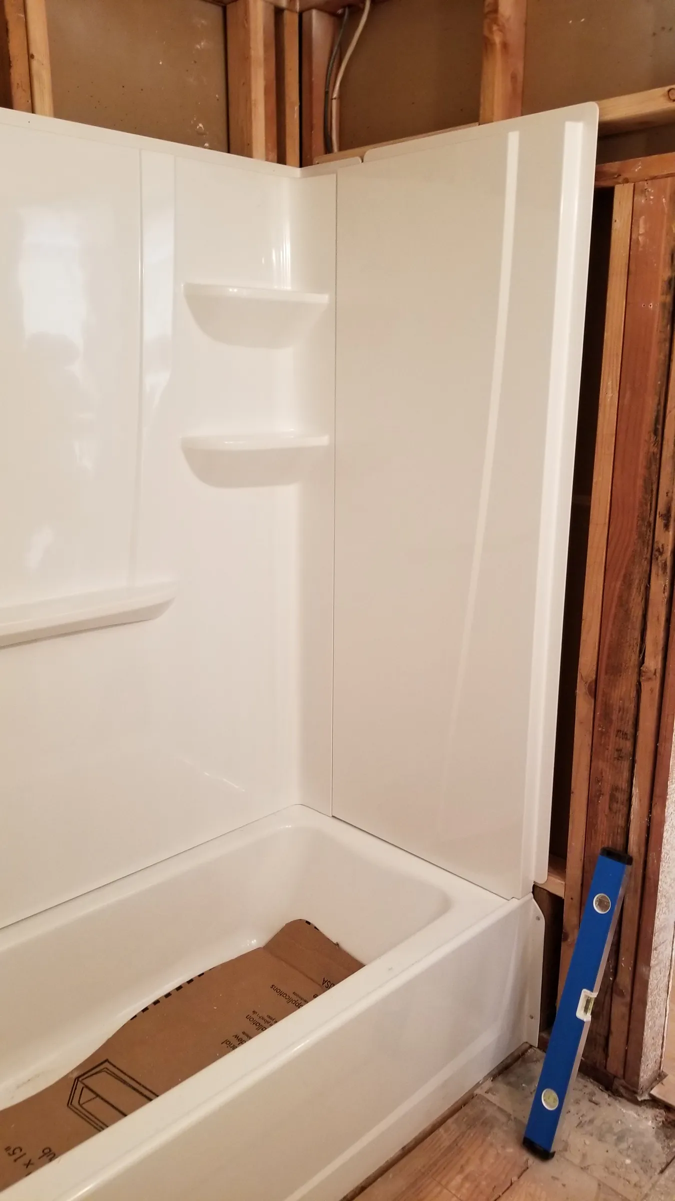 New tub leveled; surround panels in place.