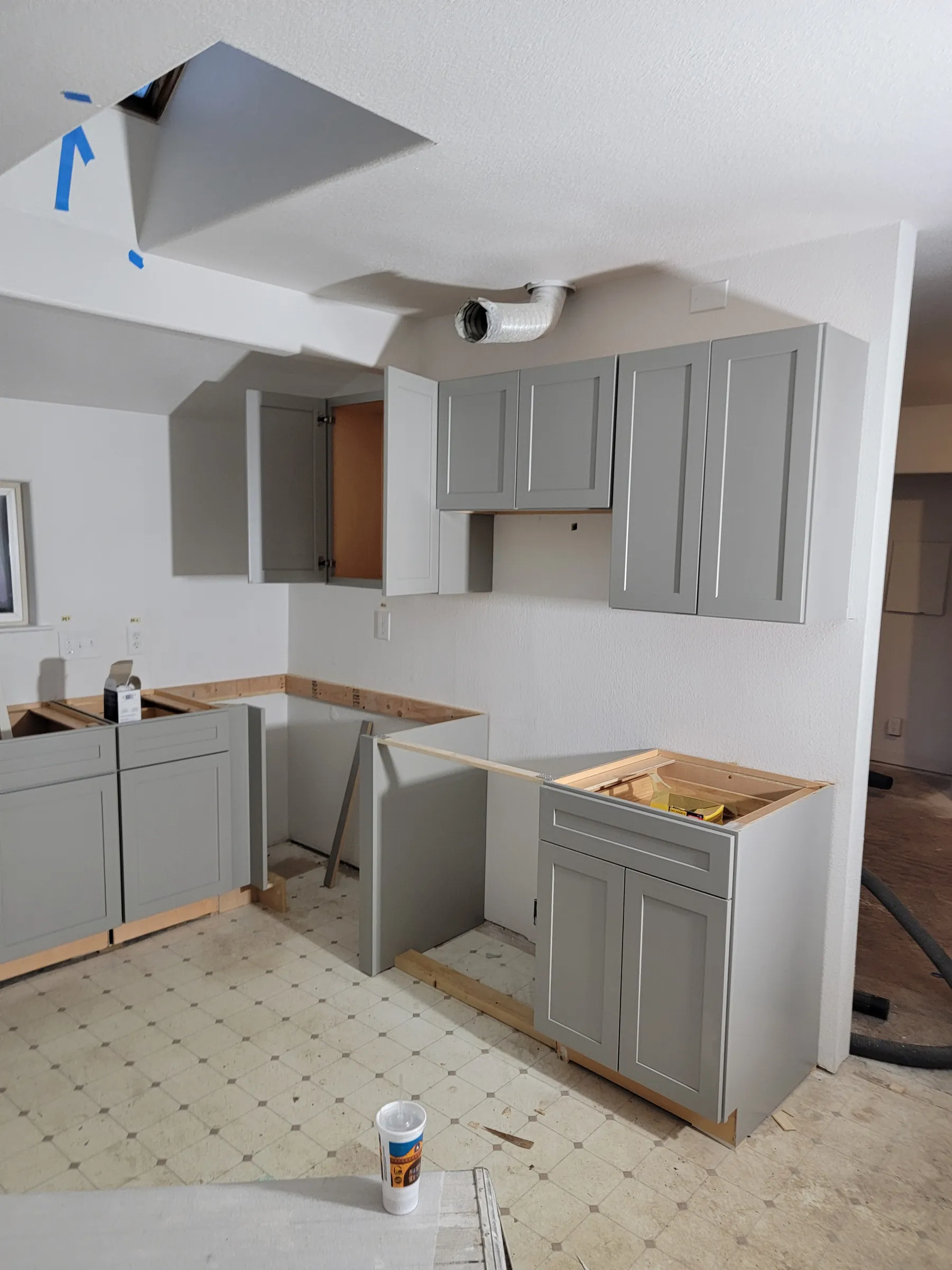 Install: Kitchen cabinets going in; the ceiling opened up for the new skylight.