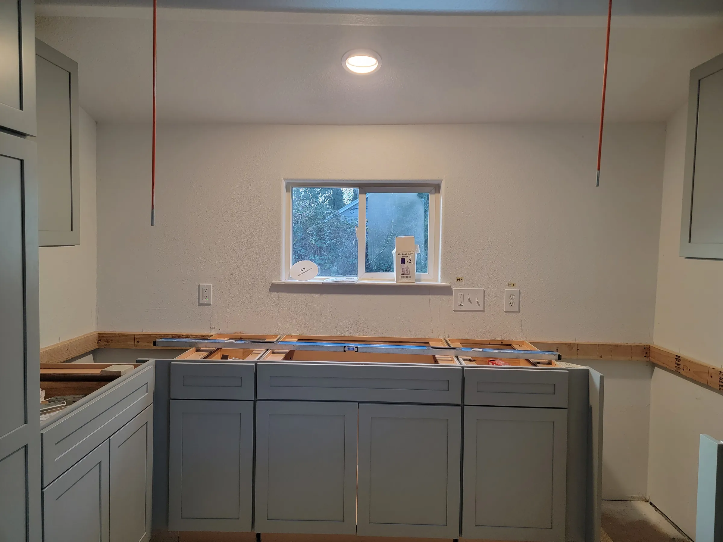 Install: The sink-wall run — cabinets in, counters still to come.