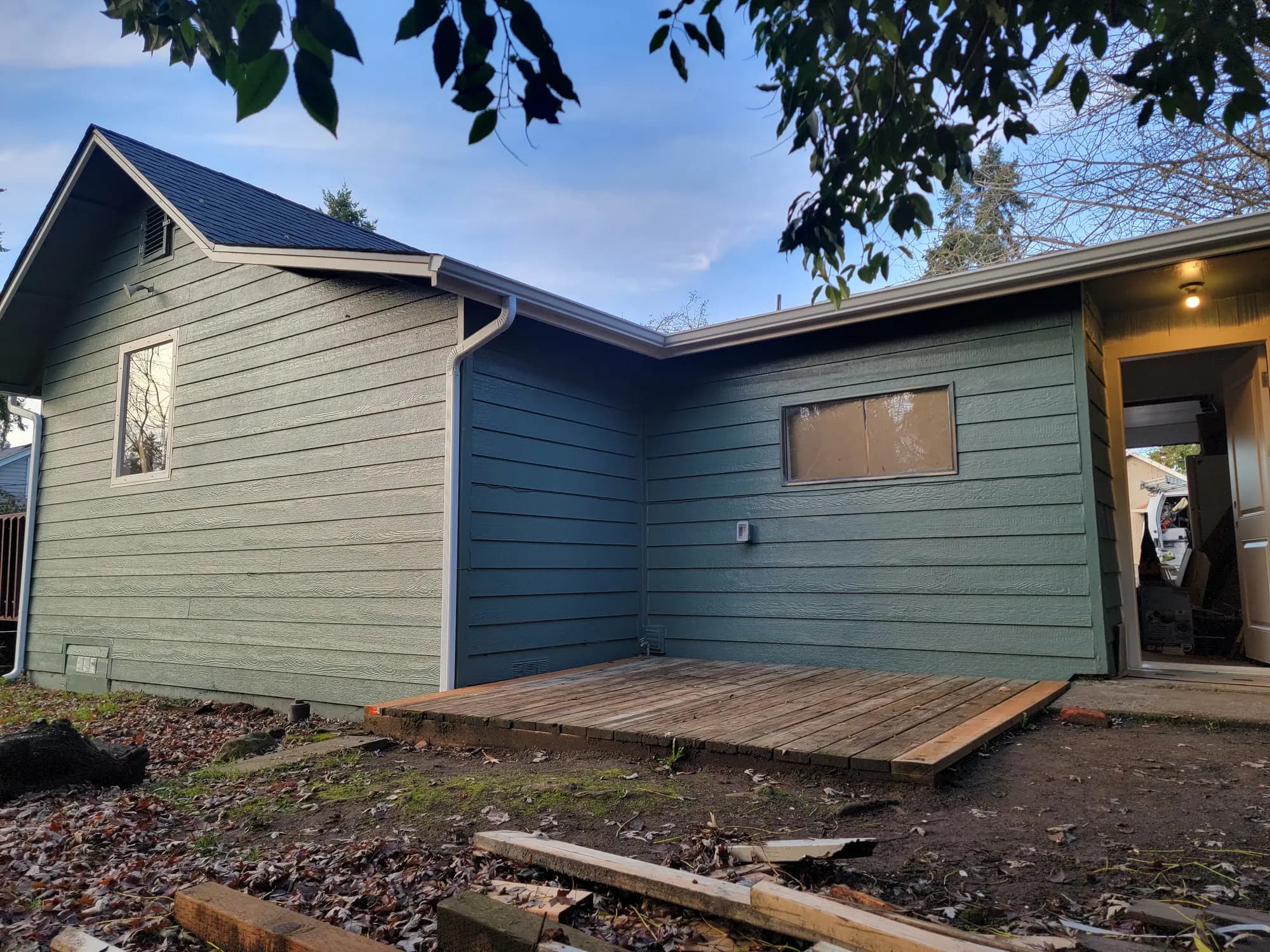 Install: New siding on the back elevation; the old deck platform still below.