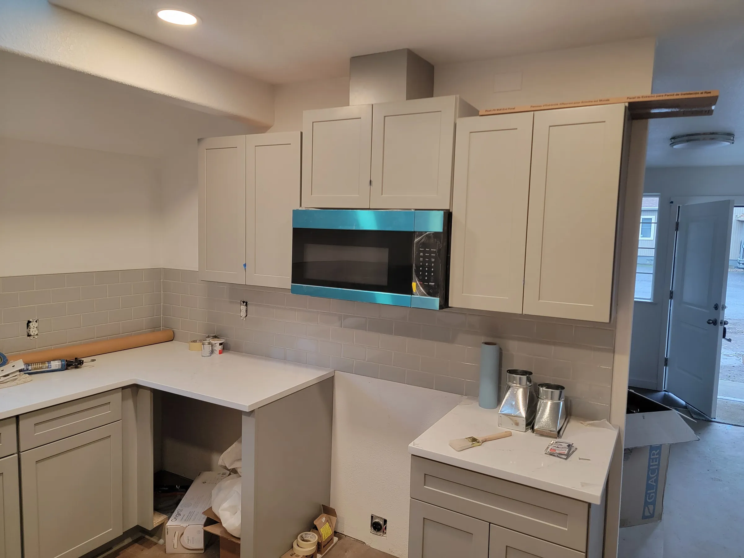Install: The kitchen's range wall — hood and microwave in, counters set.