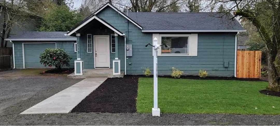 Done: The finished front — new walkway, lawn, and paint.