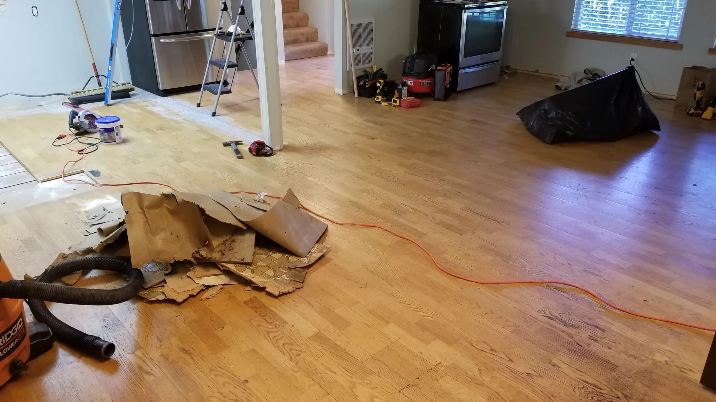 Demo: Old flooring and demo debris piled in the living area.