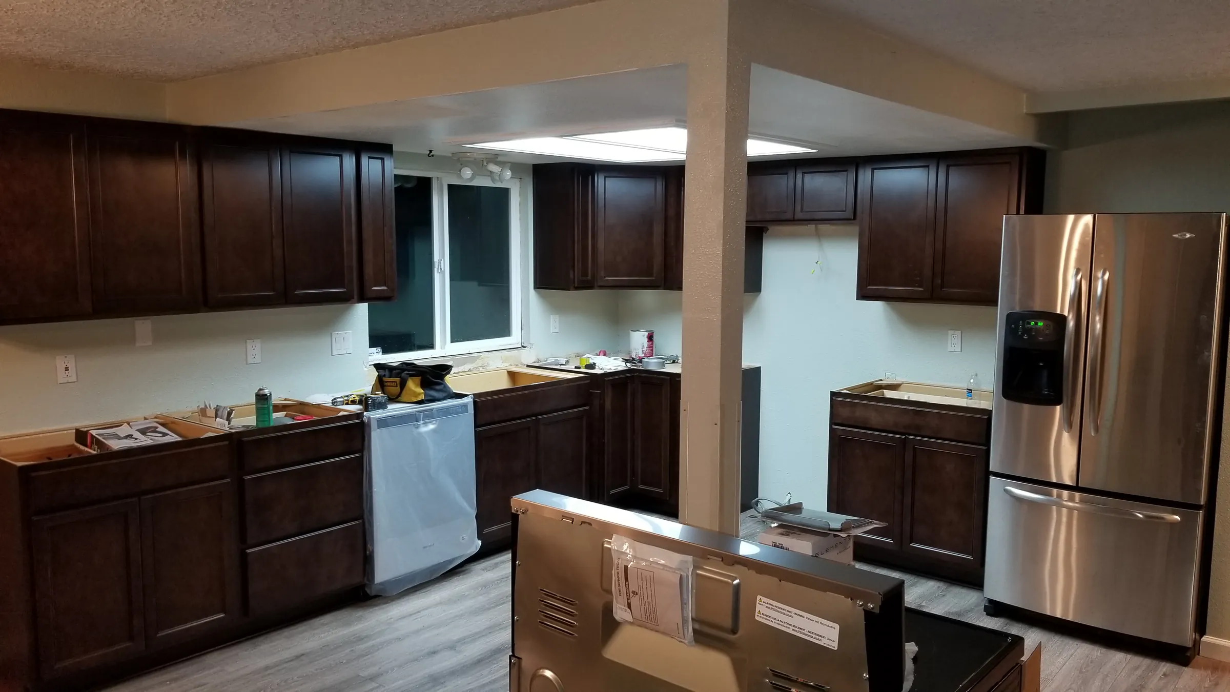 Install: New dark cabinets in and the new floor down — island still being set.