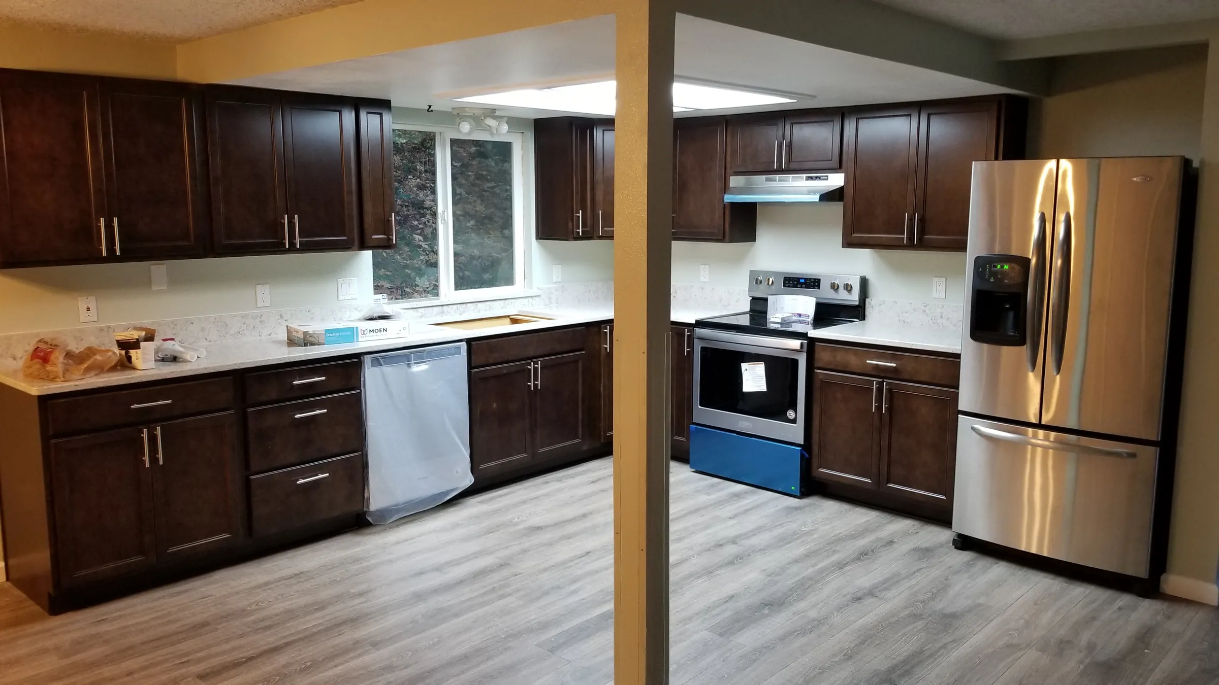 Done: The new kitchen nearly complete — stainless fridge in, range still taped.