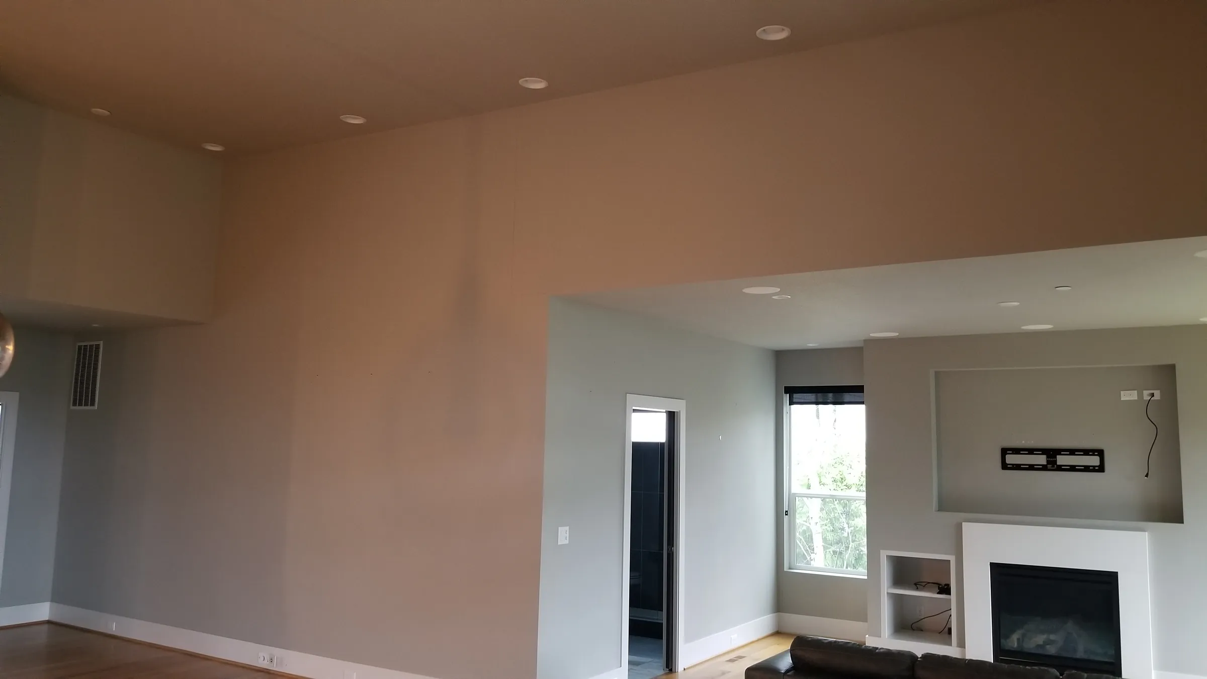 Before: The living room before work — tall walls, fireplace and TV niche.