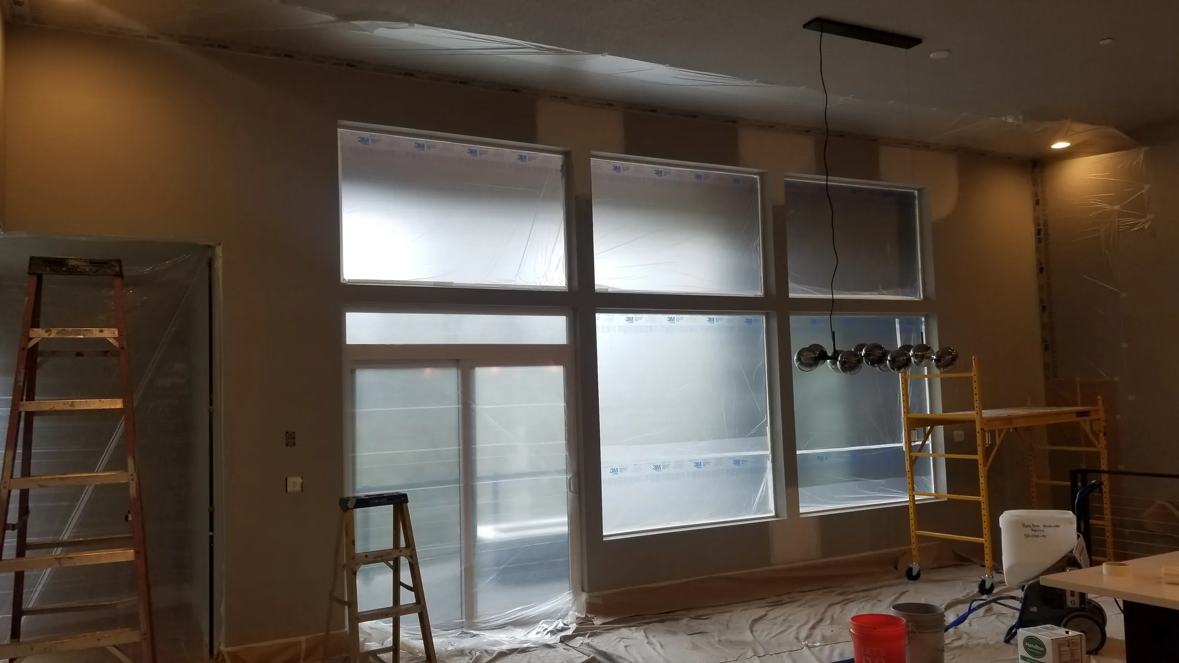 Paint: Tall windows filmed over and scaffold up in the great room.